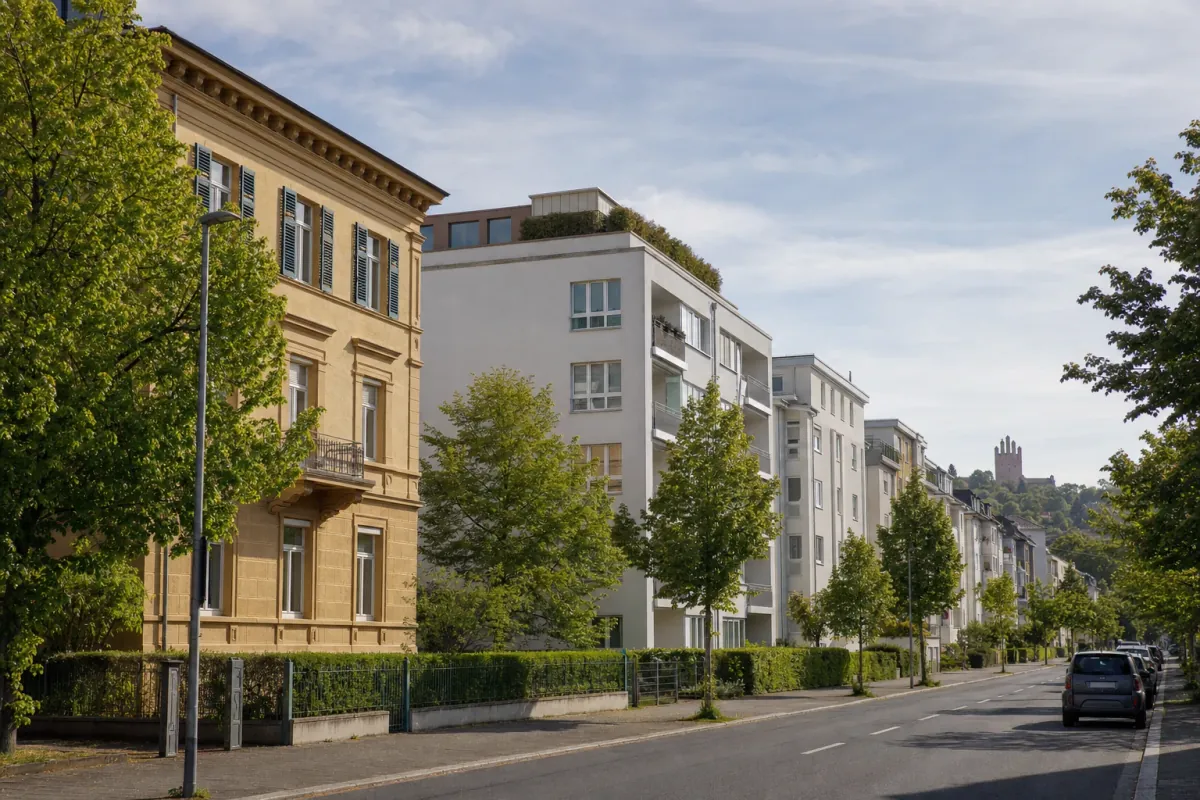Wohnstraße in Darmstadt: die für die Stadt typische Bebauung, im Hintergrund über den Dächern ein Wahrzeichen der Stadt.