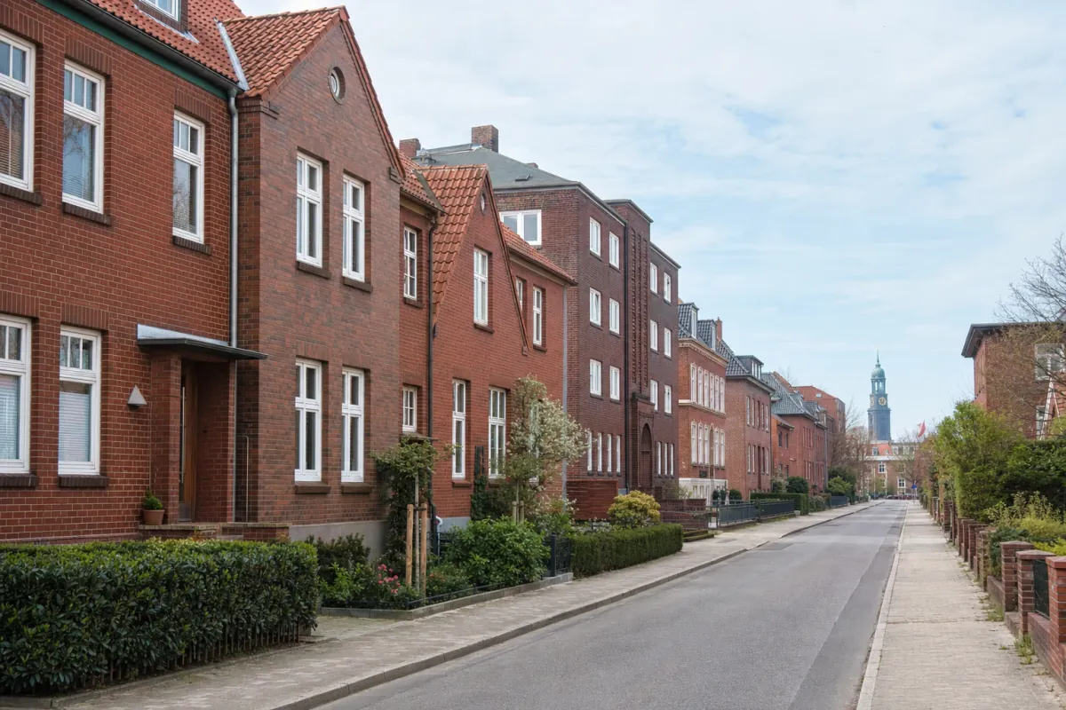 Wohnstraße in Hamburg: die für die Stadt typische Bebauung, im Hintergrund über den Dächern ein Wahrzeichen der Stadt.
