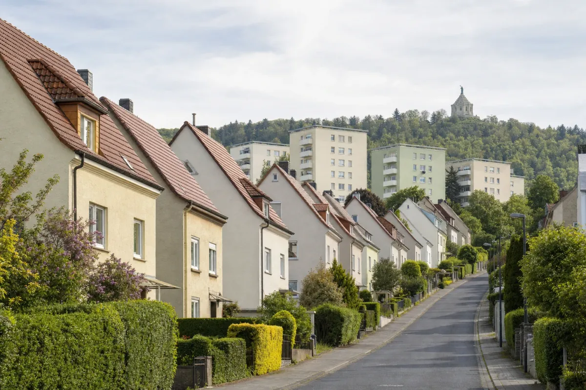 Wohnstraße in Kassel: die für die Stadt typische Bebauung, im Hintergrund über den Dächern ein Wahrzeichen der Stadt.