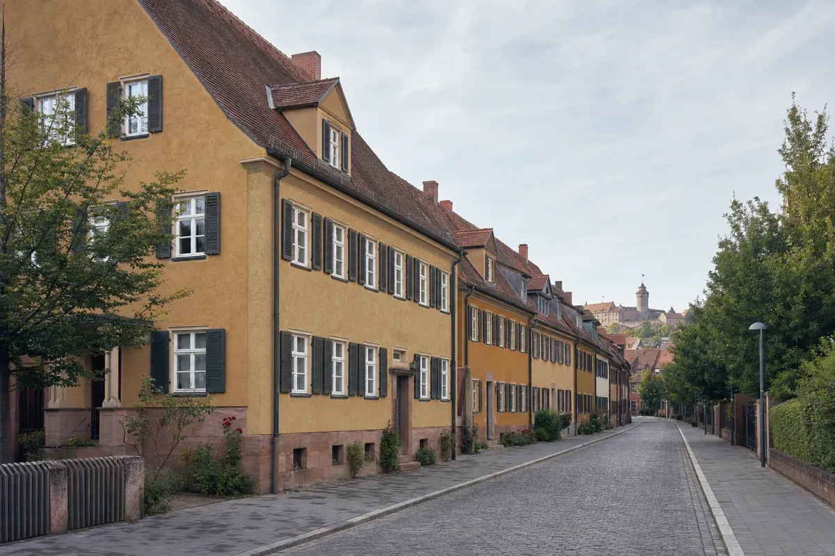 Wohnstraße in Nürnberg: die für die Stadt typische Bebauung, im Hintergrund über den Dächern ein Wahrzeichen der Stadt.