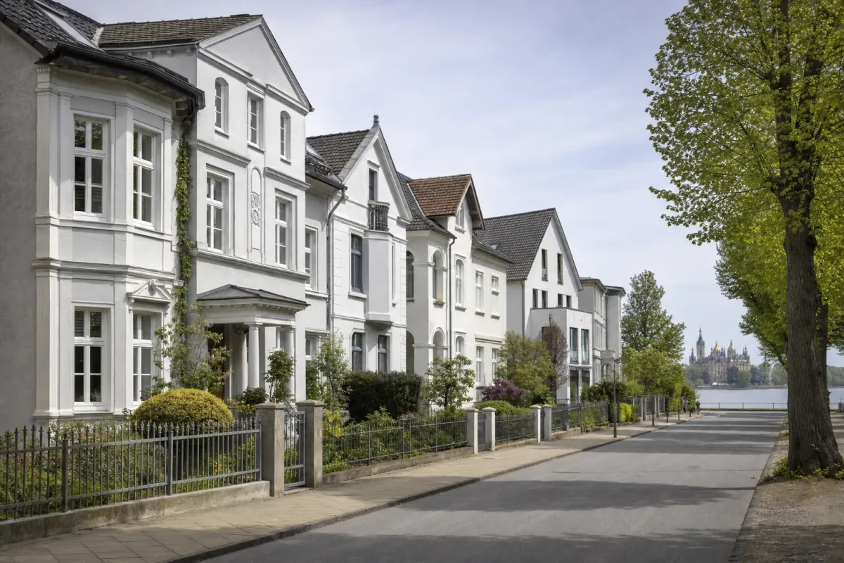 Wohnstraße in Schwerin: die für die Stadt typische Bebauung, im Hintergrund über den Dächern ein Wahrzeichen der Stadt.