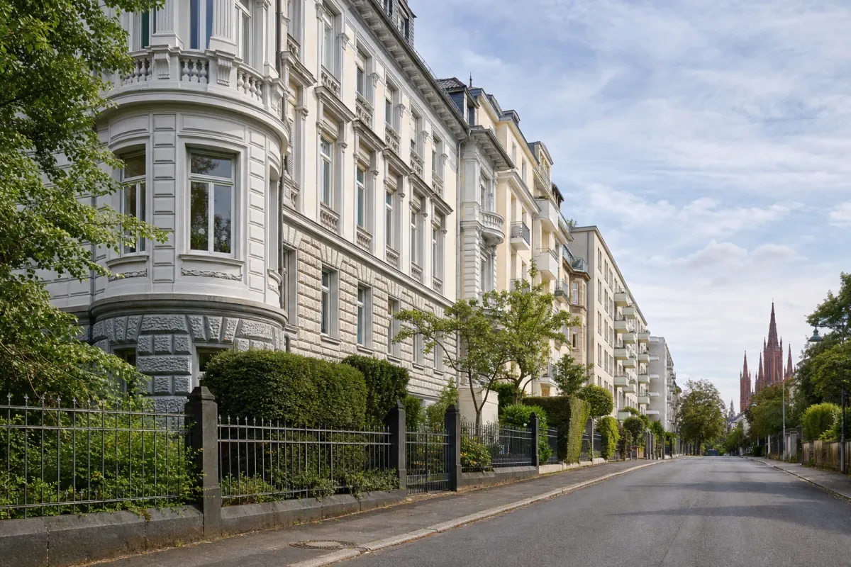 Wohnstraße in Wiesbaden: die für die Stadt typische Bebauung, im Hintergrund über den Dächern ein Wahrzeichen der Stadt.